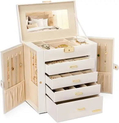 Elegant multi-tier jewelry organizer box open on a dresser displaying gold necklaces, rings, and watches against soft velvet