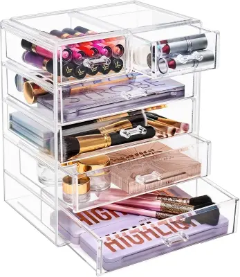 Crystal clear rotating 360-degree acrylic makeup organizer neatly holding skincare bottles on a white bedroom vanity desk