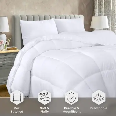 Fluffy white down alternative comforter with classic box-stitch quilting draped over a stylish wooden platform bed
