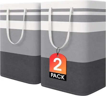 Collapsible linen fabric laundry hamper with wooden handles and fitted lid standing discreetly in a tidy bedroom corner