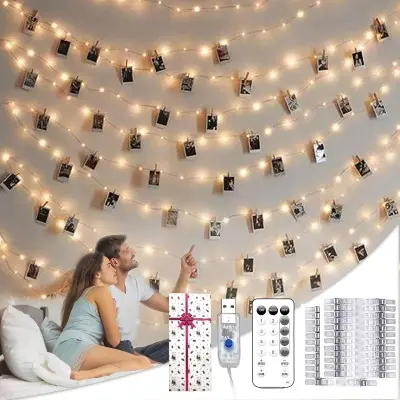 Warm fairy string lights with clear photo clips displaying travel prints illuminating a cozy teenage or guest bedroom wall