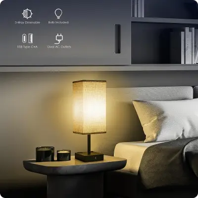 Sleek touch control bedside nightstand lamp with fabric drum shade and dual USB charging ports glowing on a wooden table