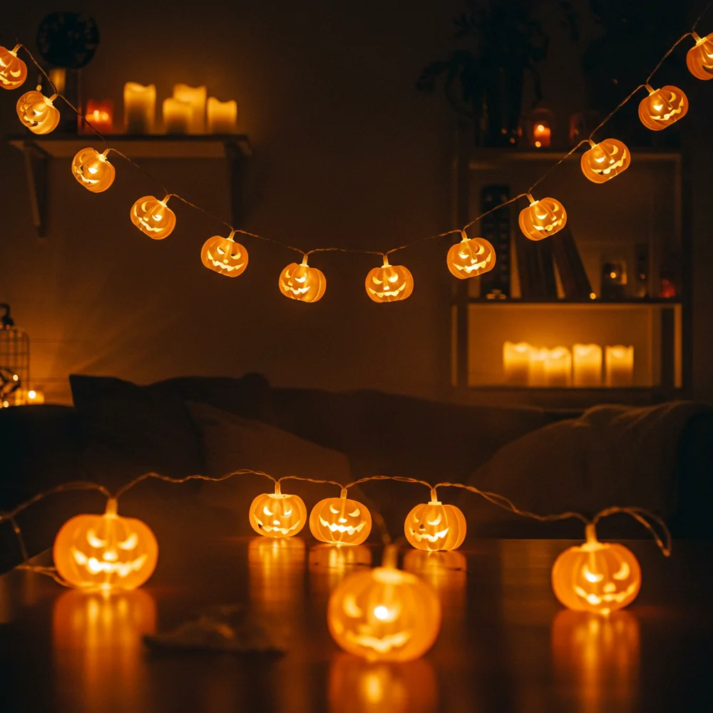 Warm flickering candlelight illuminating small spooky decorative accents and amber glassware on a dark wooden living room table