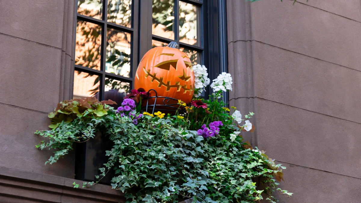 Grand New York brownstone steps exquisitely styled with cascading pumpkins, brass lanterns, dried floral arrangements, and friendly skeletons
