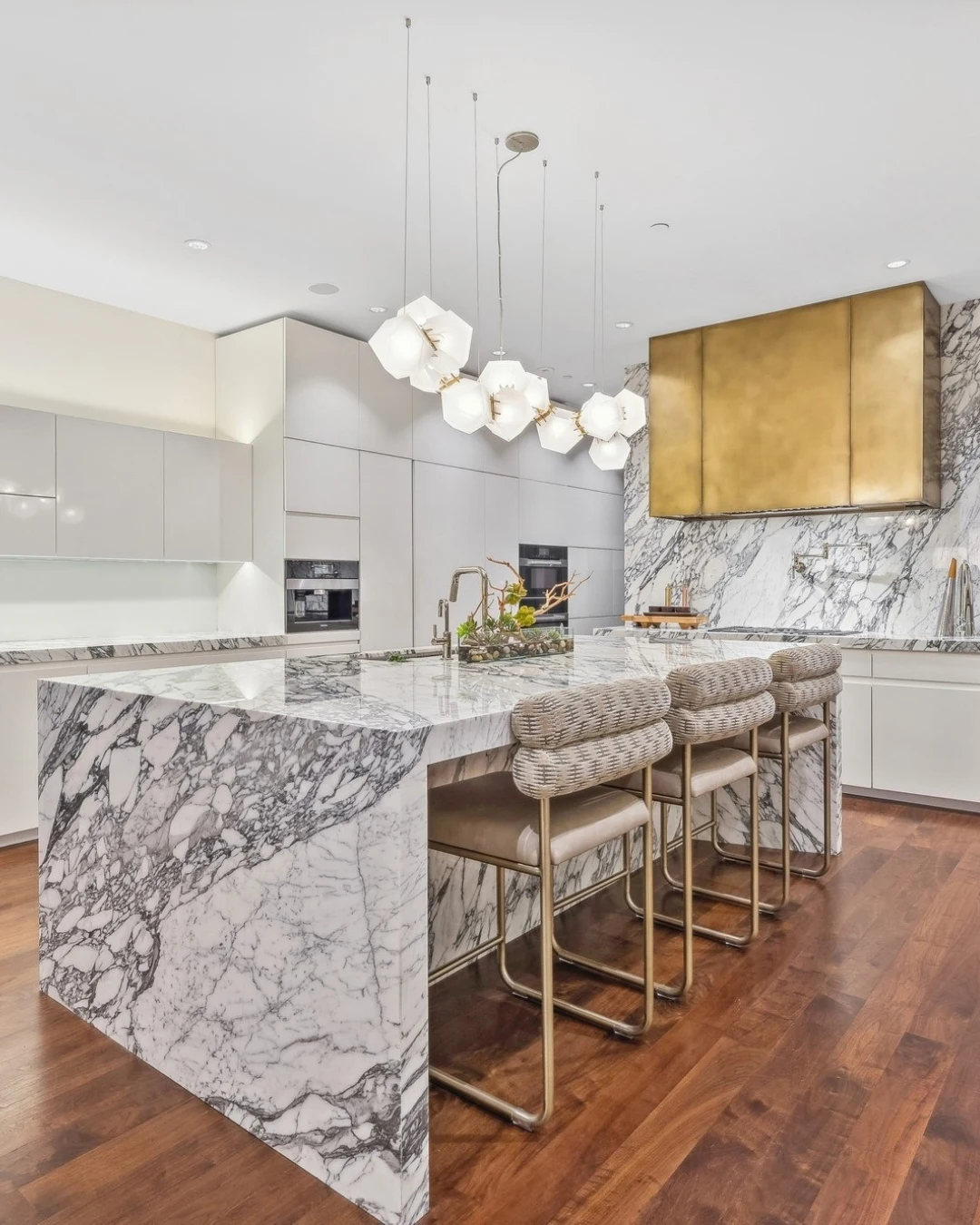 Sleek Linear LED Light Bar Suspended Over a Waterfall Kitchen Island