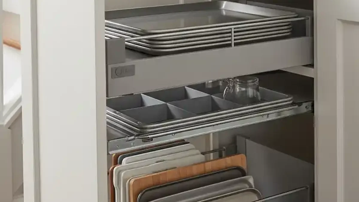 Deep pull-out tray shelving under stairs holding heavy kitchen pots, pans, and baking sheets