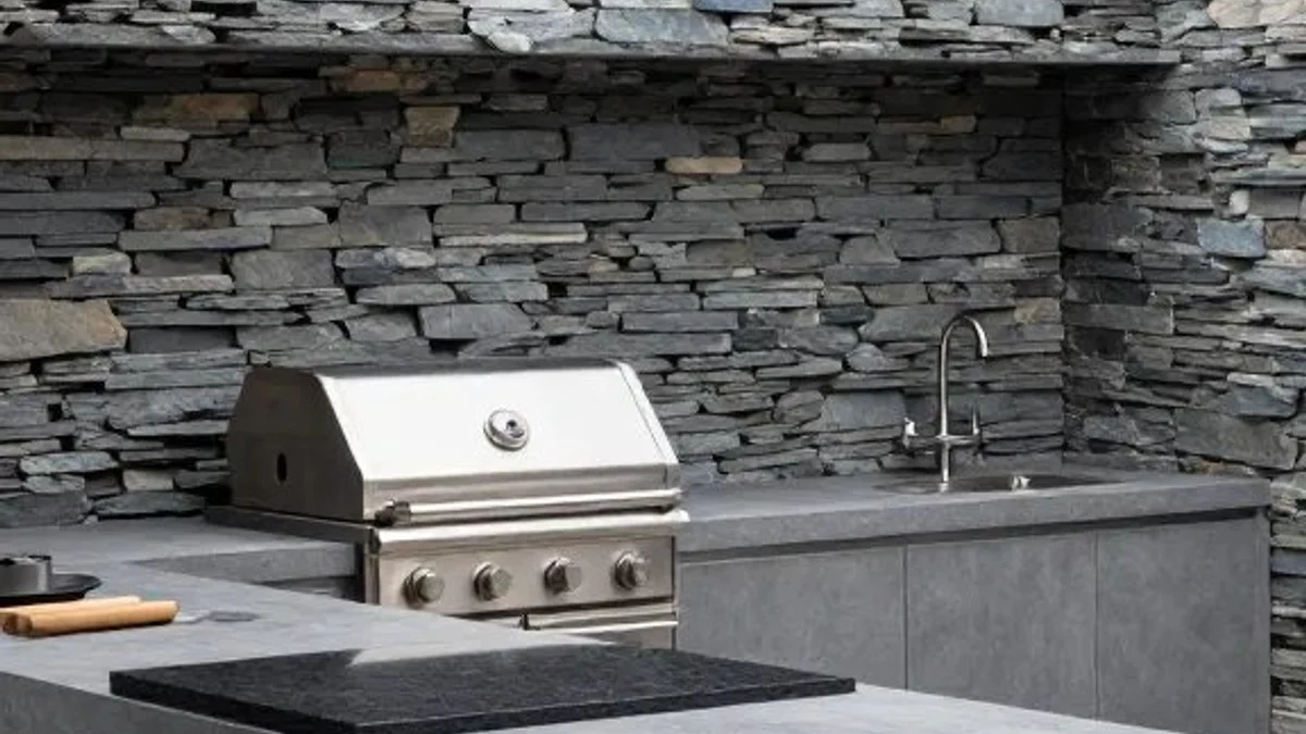 Minimalist concrete outdoor kitchen with intentional negative counter space against stacked dark slate