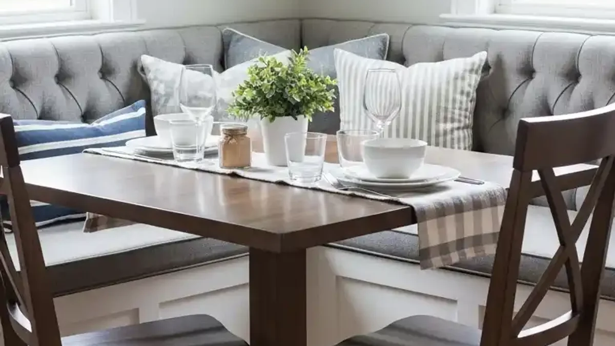 Cozy tufted built-in corner banquette seating in a bright small dining nook
